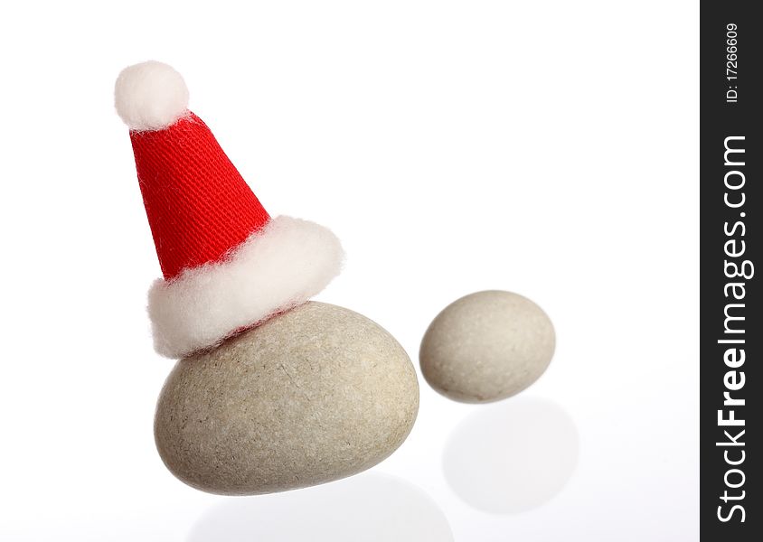 Two small stones with Santas cap isolated on white, copy space. Two small stones with Santas cap isolated on white, copy space
