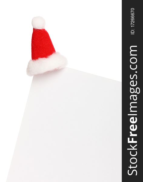 Clear sheet of paper with Santas cap isolated on white, copy space. Clear sheet of paper with Santas cap isolated on white, copy space