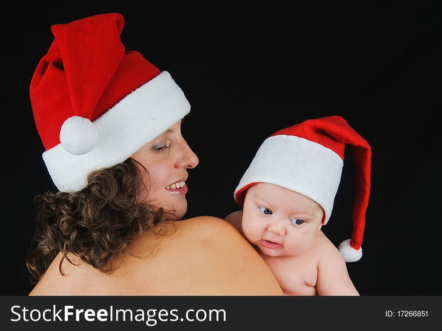 Beautiful mommy santa and her baby Santa boy on a black