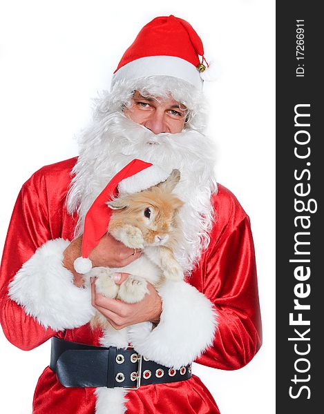 Photo of happy Santa Claus holding a cute rabbit in a santa hat.