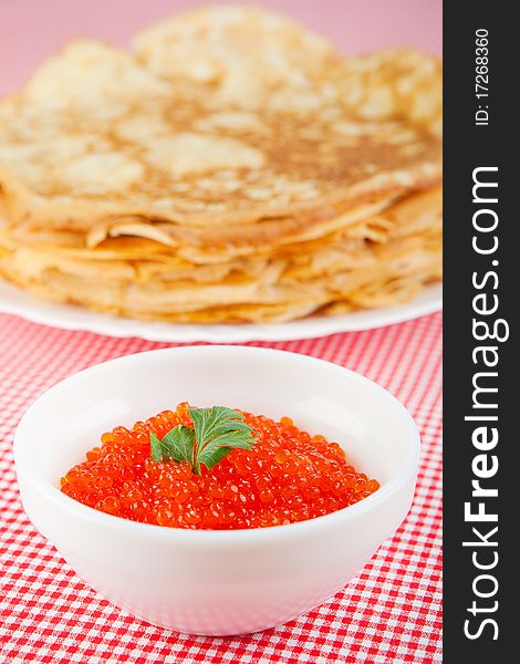 Pancakes with caviar on a red tablecloth