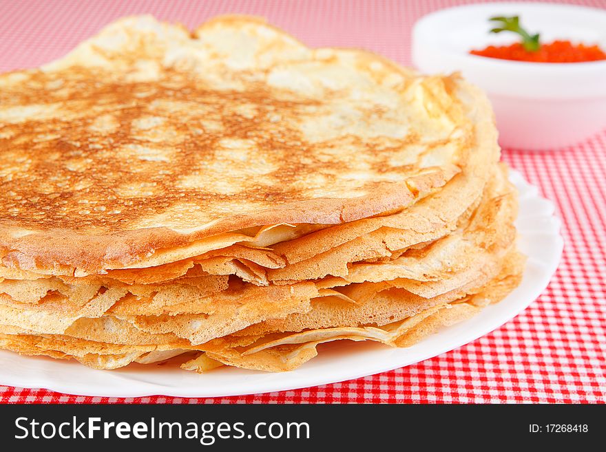 Pancakes with caviar on a red tablecloth