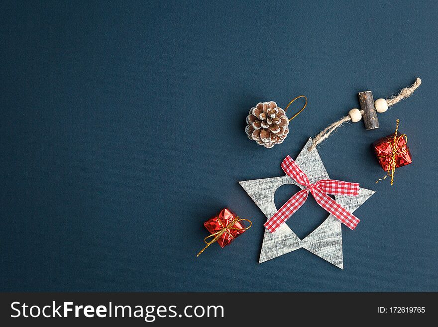 Christmas and New Year background with gifts, deer, stars and fir-trees, flat lay on a dark blue background, holiday greetings, concept of a winter background with free space