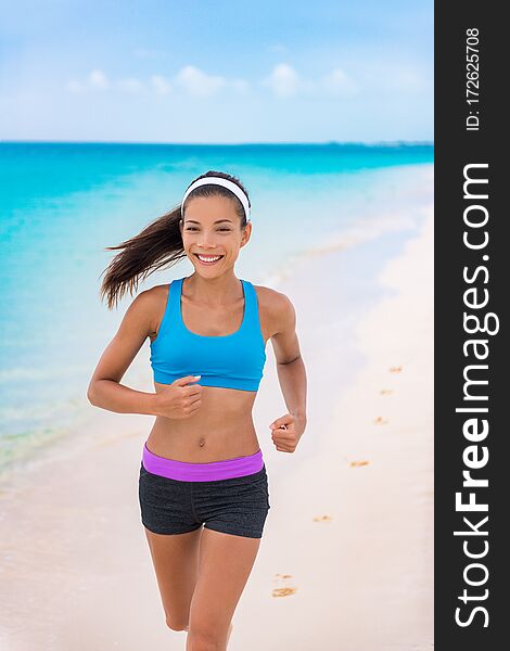 Fitness girl running on beach in fashion activewear clothes. happy Asian woman jogging with blue sports bra and shorts