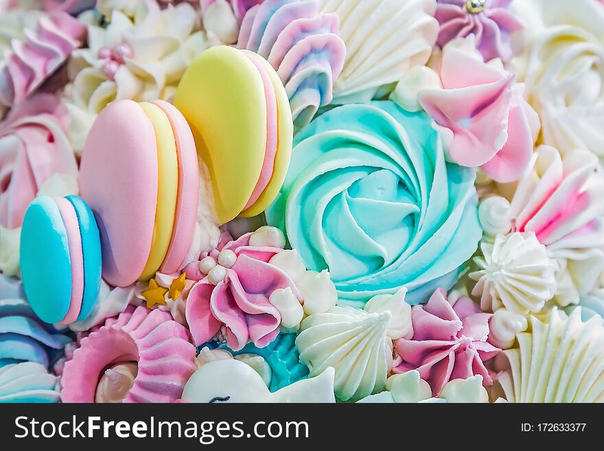 Multicolored background of marshmallow sweets, macaroon cakes and cream. Pastel shades of color