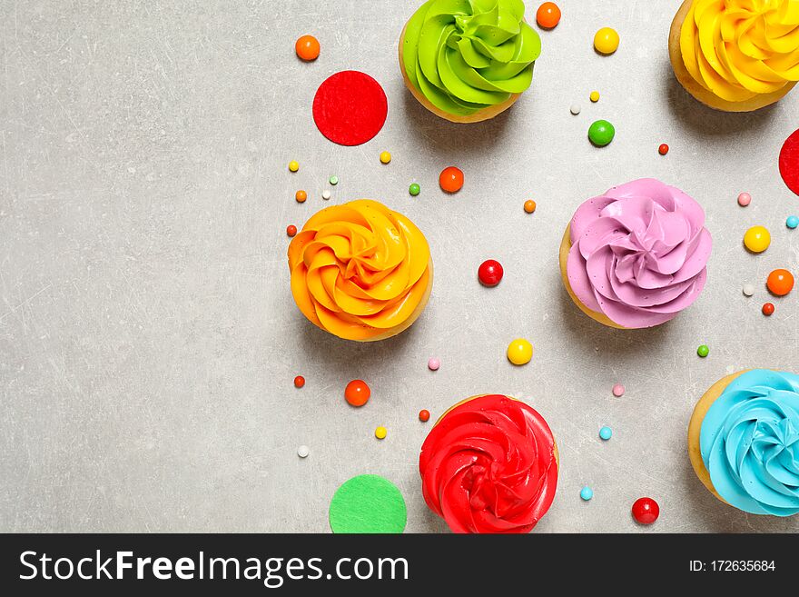 Colorful birthday cupcakes on grey table, flat lay