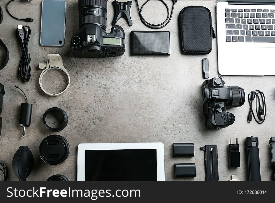 Frame made with camera and video production equipment on light grey stone background, flat lay. Space for text