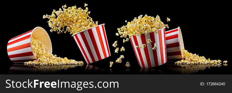 Set of paper striped buckets with popcorn isolated on black background, concept of watching TV or cinema.