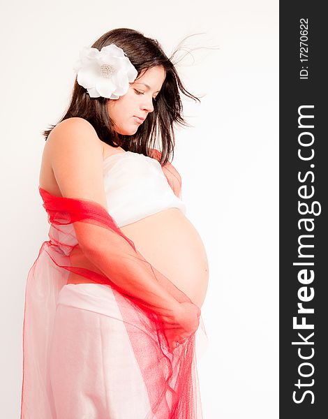 Beautiful pregnant woman staing on light grey background, close up
