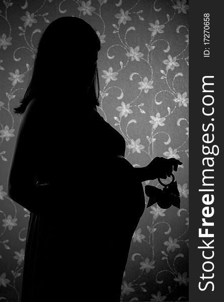 A silhouette of a pregnant woman at studio. A silhouette of a pregnant woman at studio