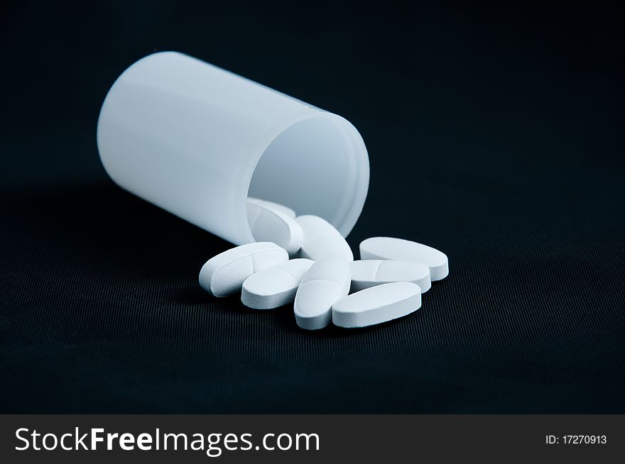 White tablets in a box on a black background