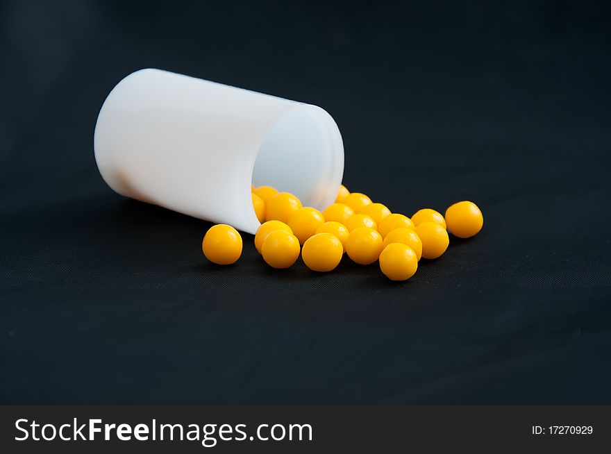 Yellow pills in a box on a black background. Yellow pills in a box on a black background