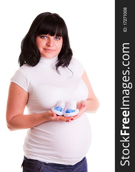 Pregnant woman holding baby's bootee on white