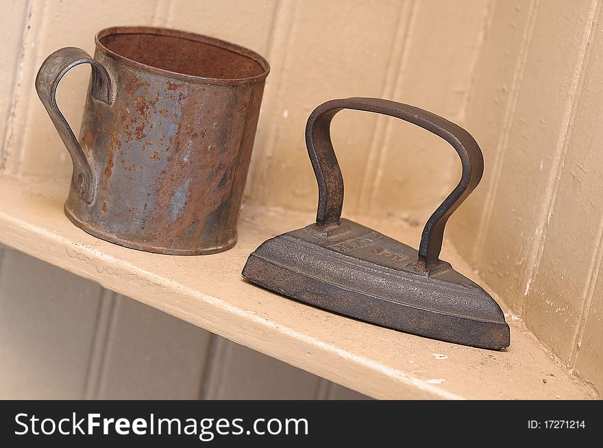 An old iron and mug on a shelf