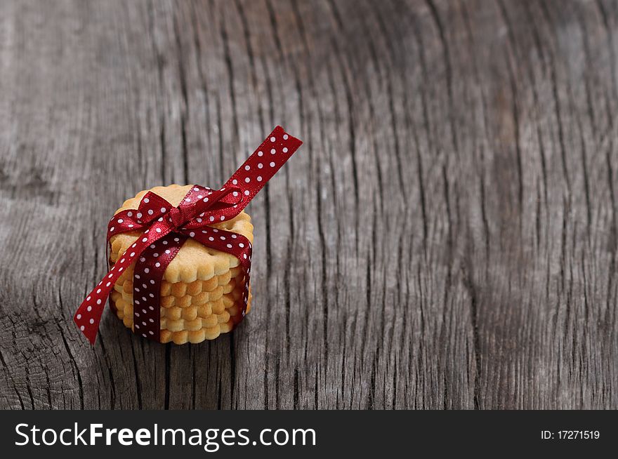 Cookies decorated with dark red polka dots ribbon on the wooden background. Cookies decorated with dark red polka dots ribbon on the wooden background