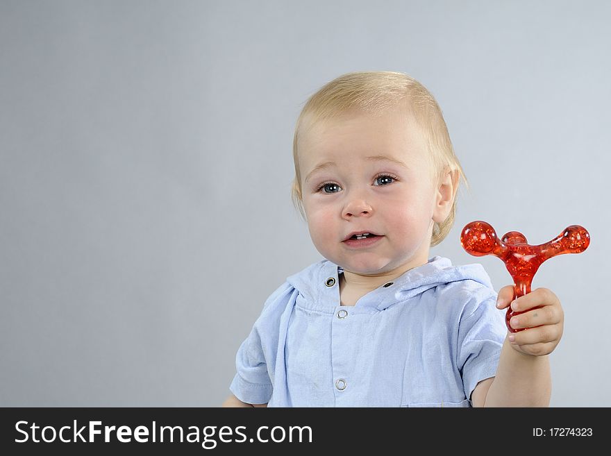 Beautiful baby boy having fun with red toy. Beautiful baby boy having fun with red toy