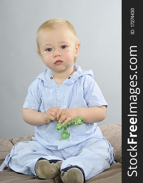 Beautiful baby boy having fun with green toy. Beautiful baby boy having fun with green toy