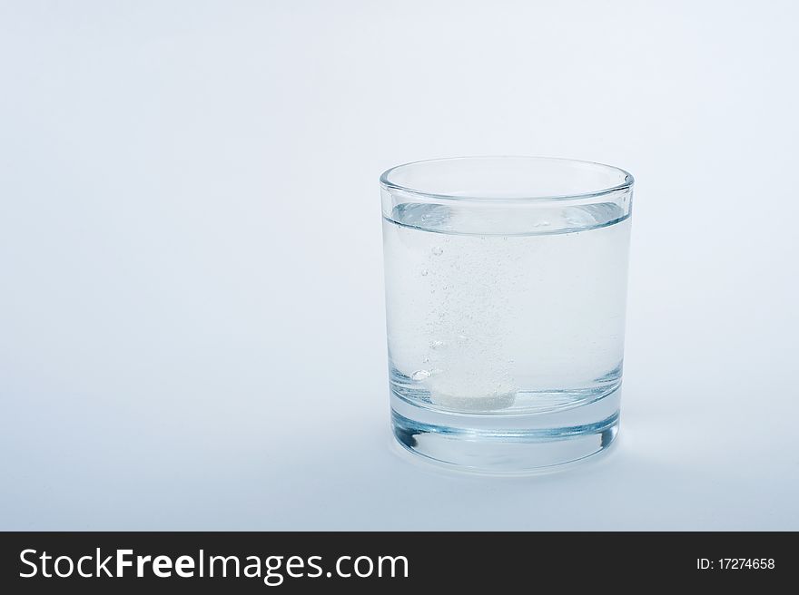 Water in a transparent glass on a blue background. Water in a transparent glass on a blue background