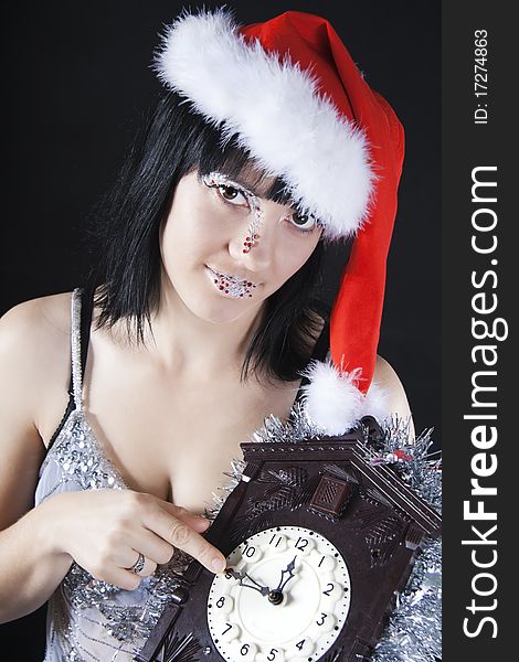 The girl in a Santa's hat holding the clock