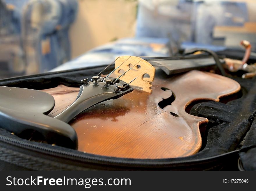 The old violin lays in a case