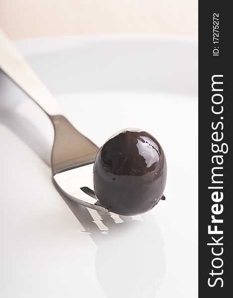 Close up black olive on a fork