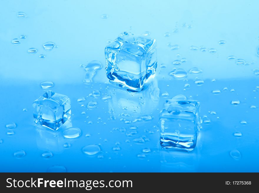 Three blue Ice cubes with water drops