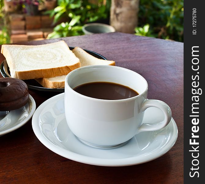 Cup of coffee and bread on table