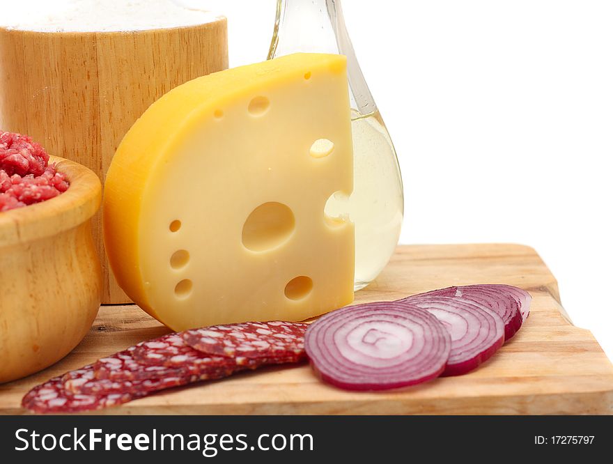 Ingredients for making pizza with cheese and sausage on a white background.