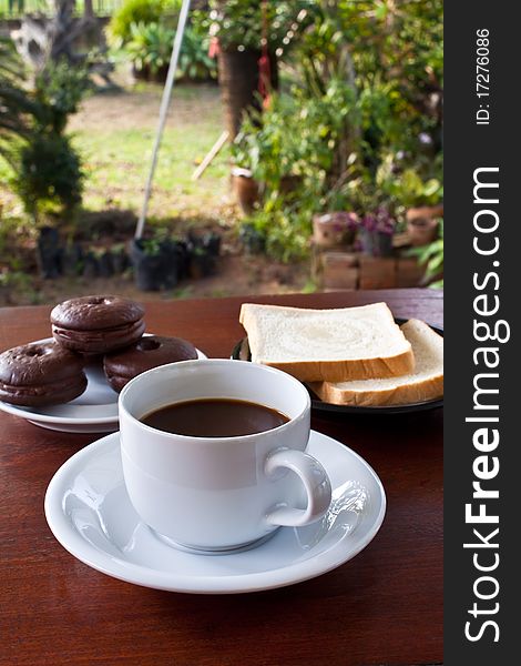 Cup of coffee and bread on table