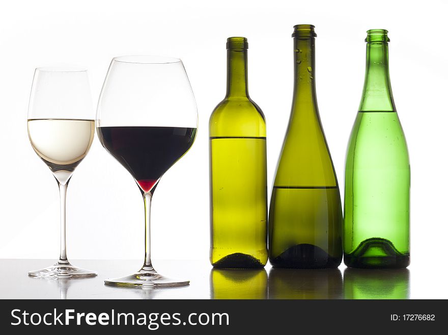 Two glass of red and white wine with three glass bottles. Two glass of red and white wine with three glass bottles