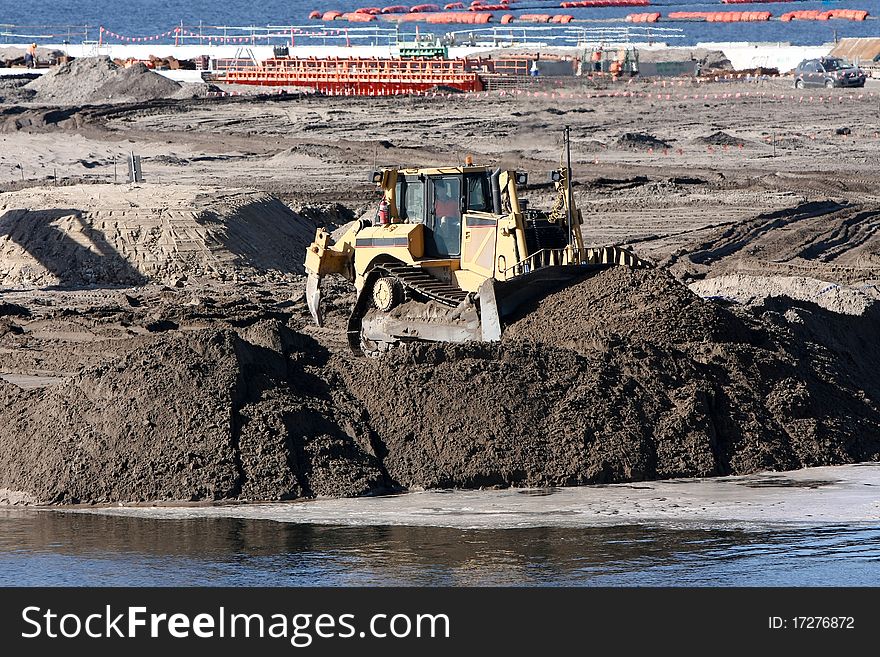 Large bulldozer pushing gravel on construction site. Large bulldozer pushing gravel on construction site