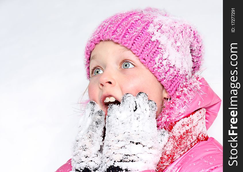Little girl in winter pink hat in snow . Little girl in winter pink hat in snow .