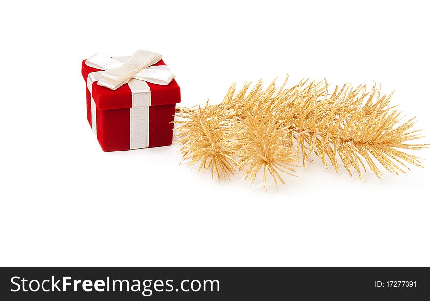 Red and gold gift box with fir branches on a white background