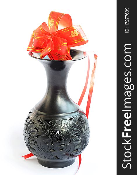 Black vase with artificial red flowers on a white background. Black vase with artificial red flowers on a white background