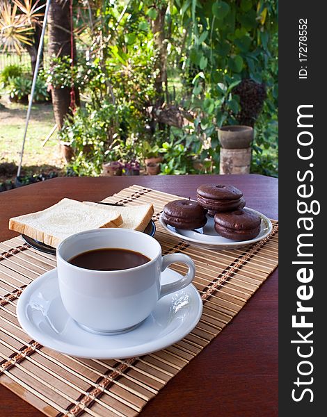 Cup of coffee and bread on table