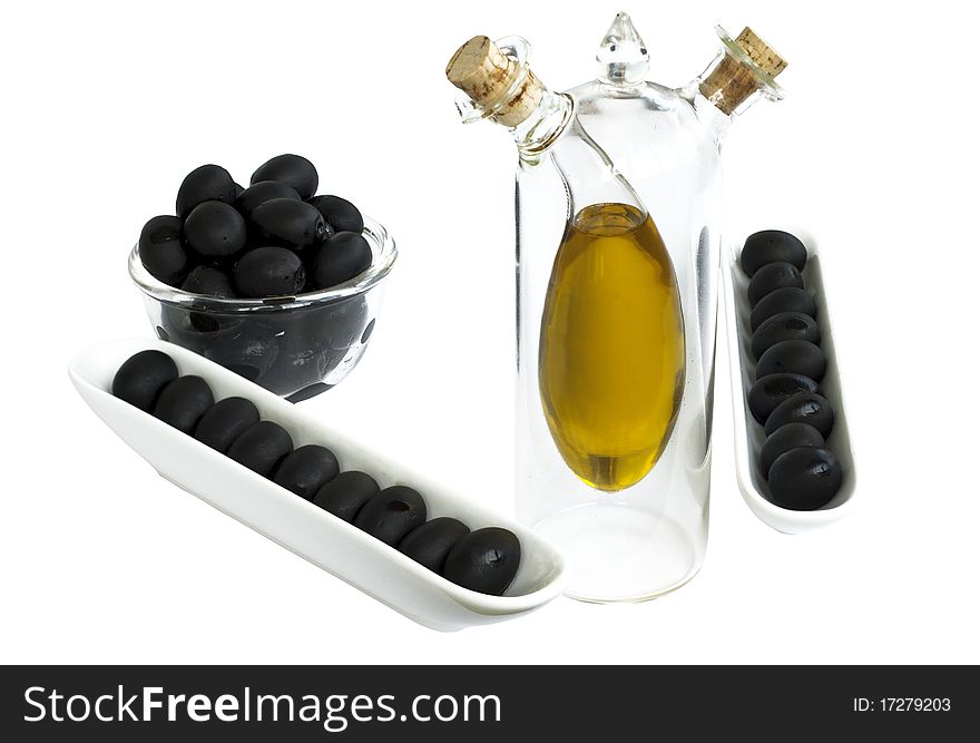 Black olives in bowl and olive oil in bottle. Black olives in bowl and olive oil in bottle