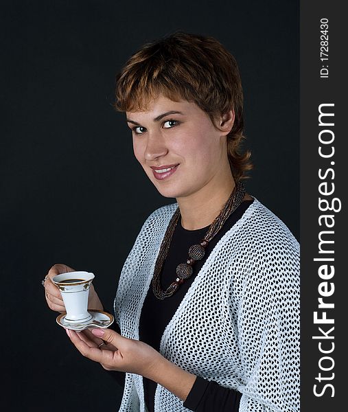 Girl with a cup of coffee on a dark background