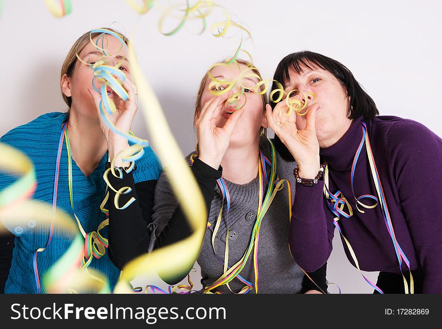 Two young women and her mother celebrating New year's eve. Shot taken in front of white background. Two young women and her mother celebrating New year's eve. Shot taken in front of white background