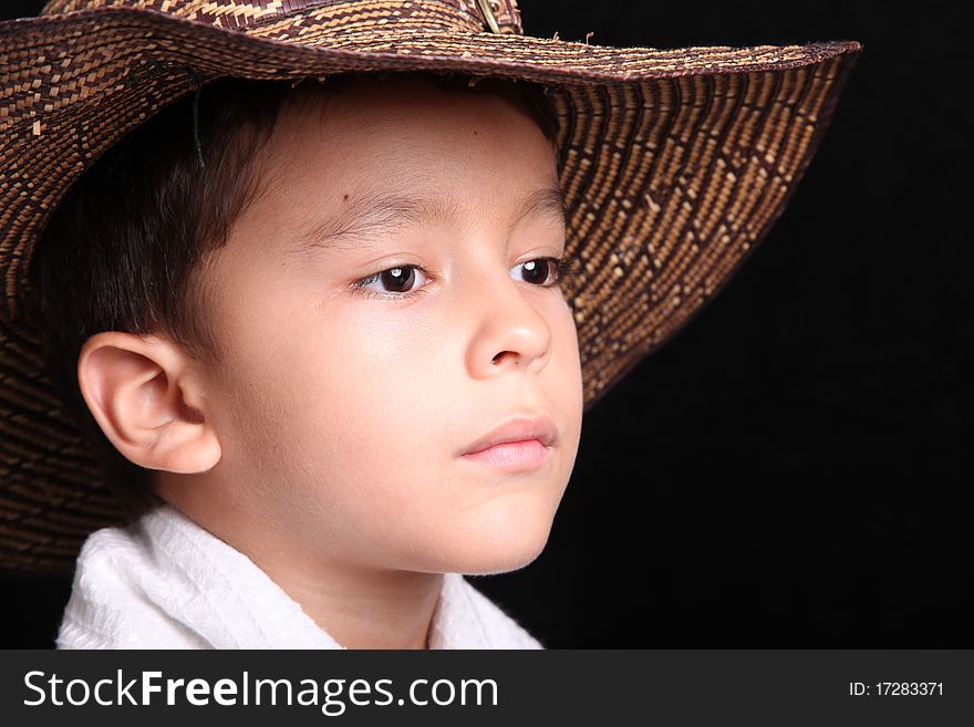 Six years old child looking with hat on black background