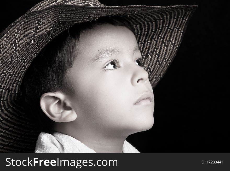 Child with a hat looking up in black and white