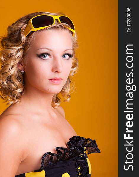 Beautiful blonde haired woman on yellow background, close up