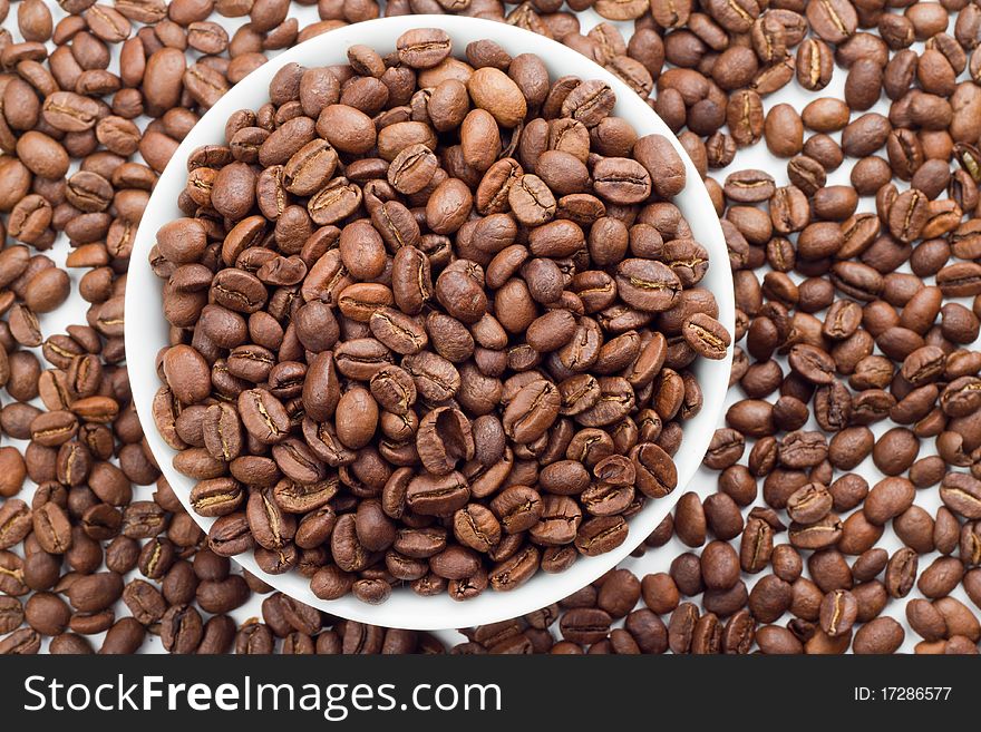 Close up of Coffee beans in bowl and around a white bowl