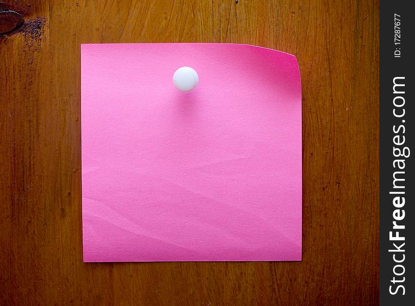 Pink blank reminder on a wood desk with white push pin