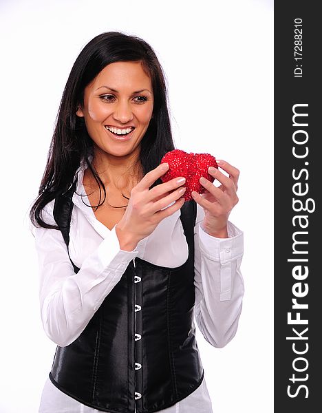 Portrait of a charming young girl on a white background holding a heart