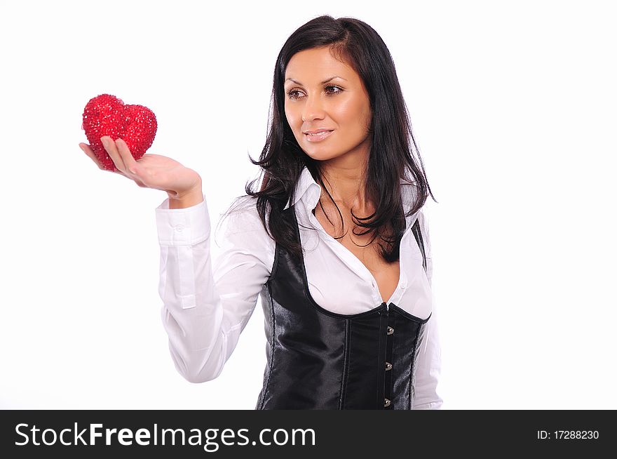 Portrait of a charming young girl on a white background holding a heart