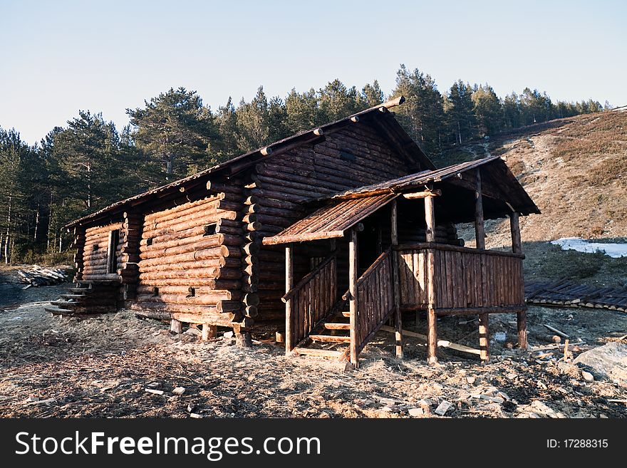 Wooden house in the medieval style on the background of the forest