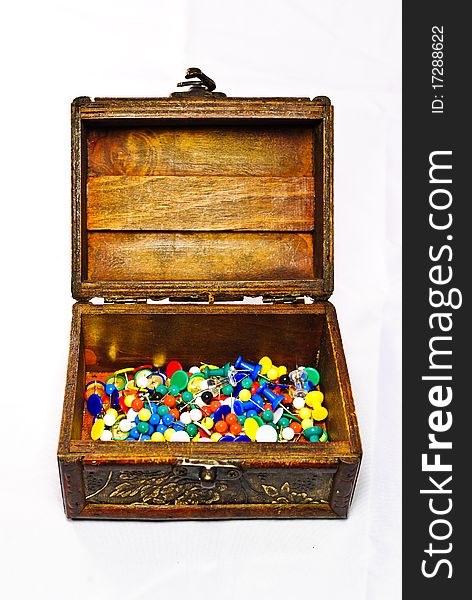 Brown opened chest filled with many colored pins. Brown opened chest filled with many colored pins