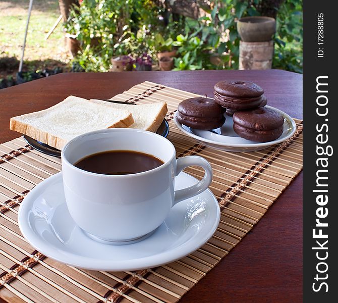 Cup of coffee and bread on table