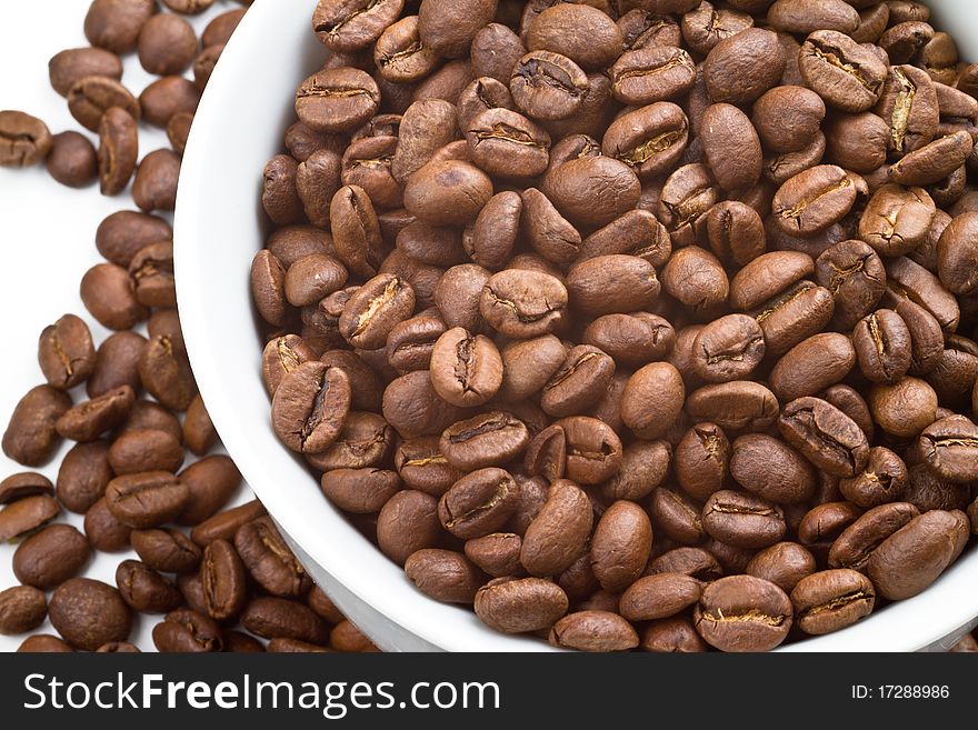 Close up of Coffee beans in bowl and around a white bowl