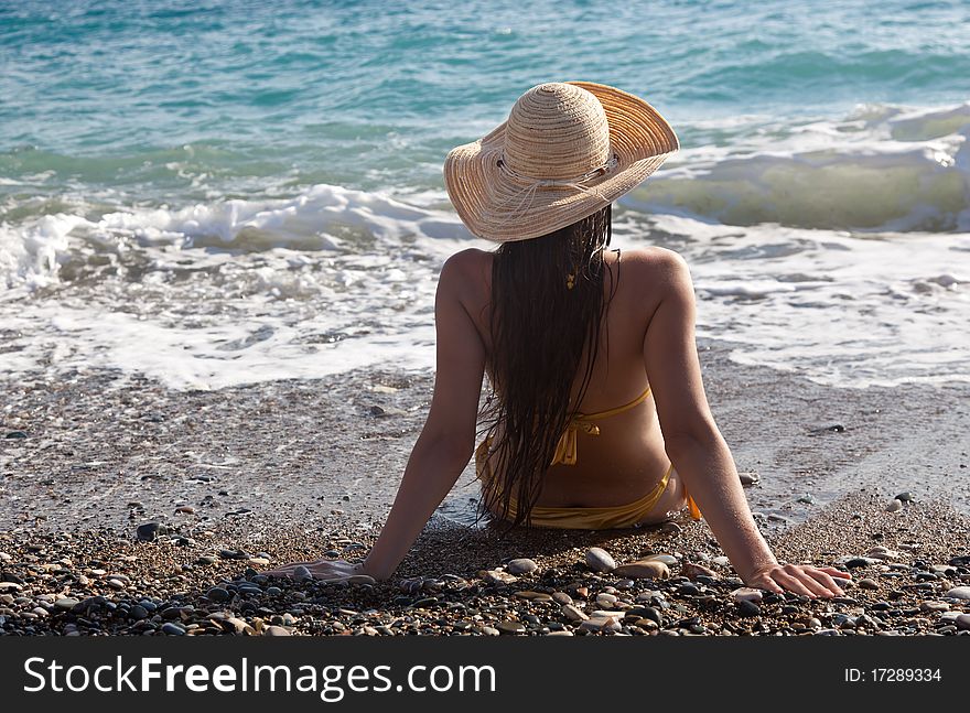 A woman in a bonnet is looking to the sea. A woman in a bonnet is looking to the sea